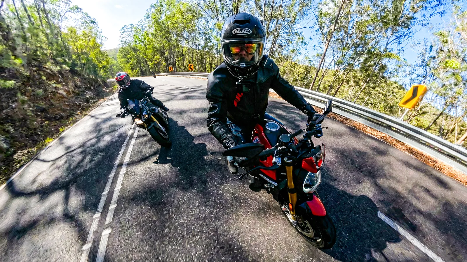 Two riders through a corner on a mountain road