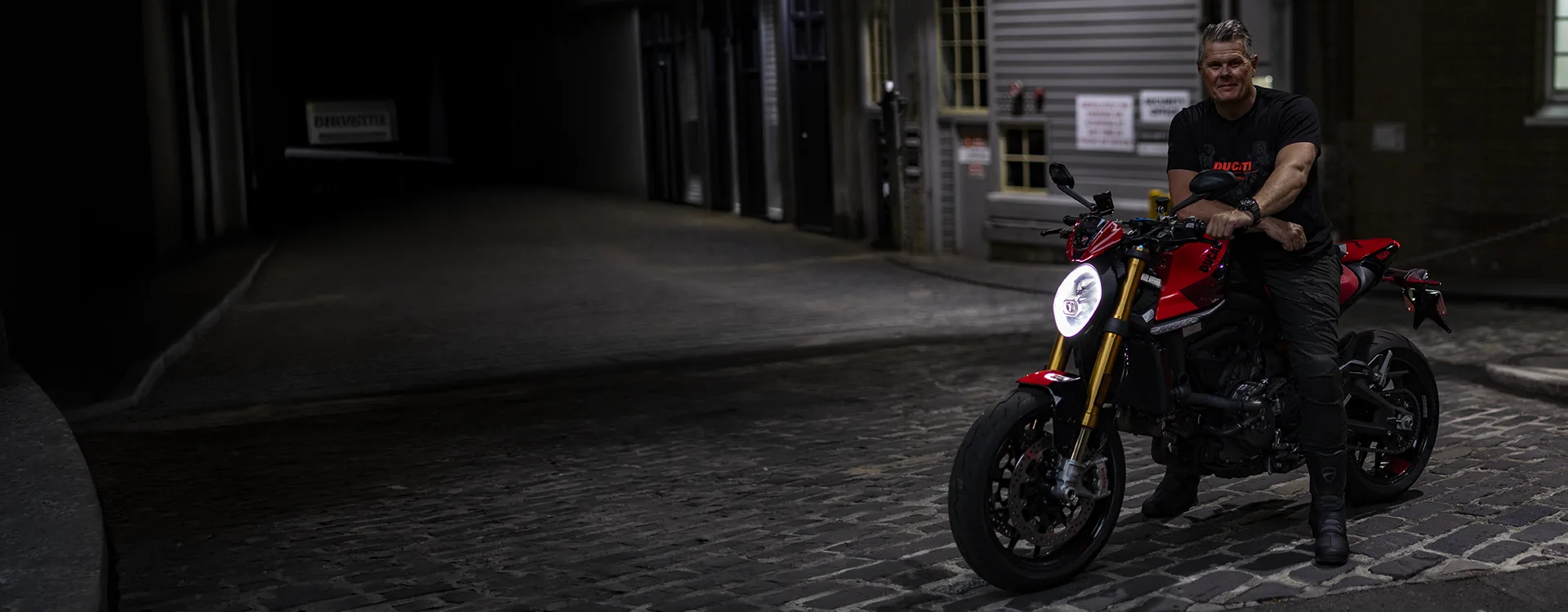 Moto Swinger and his Ducati Monster in a cobbled laneway at night
